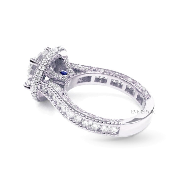 Pia Sapphire White engagement ring - front left view - hand-cut Everspark Moissanite, cathedral setting, halo, pave sidestones, milgrain details, peekaboo sidestones, 7mm, 7.5mm, or 8mm round cut center stone, available in 18k White Gold, 18k Yellow Gold, 18k Rose Gold, Platinum 950, Blue Sapphire, Pink Sapphire, Ruby or Emerald sidestones, video: Pia Platinum with Blue Sapphire sidestones, 8mm center stone.